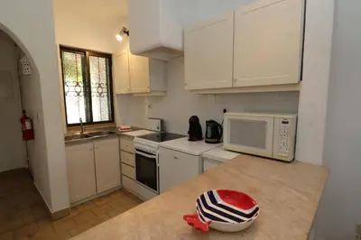 a kitchen with white cabinets and a counter top with a microwave at Studio Camélia 68 at São Rafael Beach - Albufeira in Albufeira