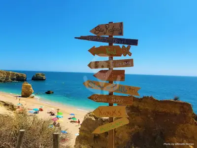 a street sign with many signs on a beach at Studio Camélia 68 at São Rafael Beach - Albufeira in Albufeira