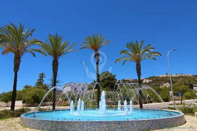 a fountain with water fountains in front of palm trees at Studio Camélia 68 at São Rafael Beach - Albufeira in Albufeira