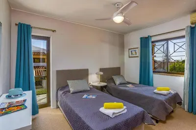 two beds in a room with blue curtains at Villa Tadeu Quatro by Villa Plus in Azinhal