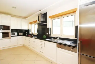 a kitchen with white cabinets and a stainless steel refrigerator at Villa Anna by Algarve Vacation in Albufeira