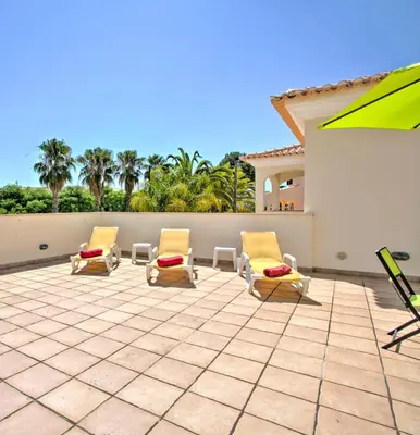 a patio with two lounge chairs and a wall at Villa Anna by Algarve Vacation in Albufeira