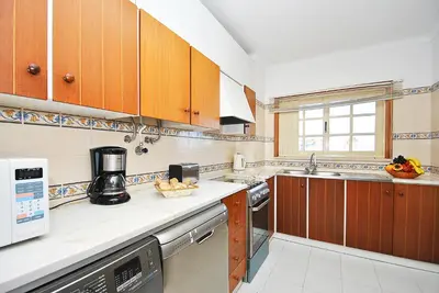 a kitchen with wooden cabinets and a counter top at Apartment Formentera by Algarve Vacation in Albufeira
