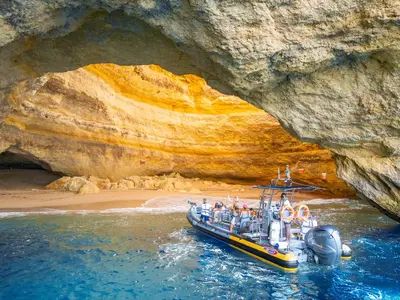 a boat in the water in front of a cave at Apartment Atlantic Sea by Algarve Vacation in Albufeira