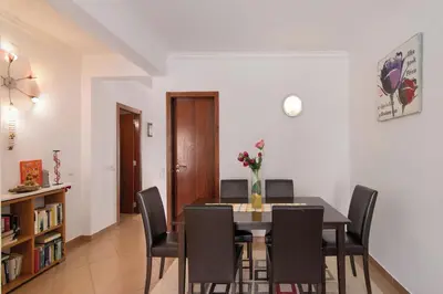 a dining room with a table and chairs at Espaçoso apt T2, em Olhos Agua in Albufeira