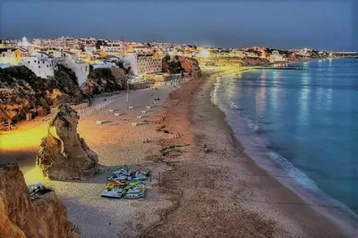 a view of a beach with boats on the shore at Espaçoso apt T2, em Olhos Agua in Albufeira
