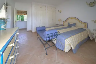 a bedroom with a large bed with a blue comforter at Villa Pinheiro Manso in Albufeira