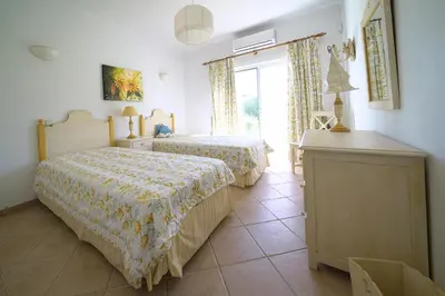 a bedroom with two beds and a window at Villa Pinheiro Manso in Albufeira