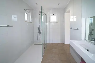 a white bathroom with a shower and a sink at Villa Pinheiro Manso in Albufeira