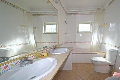 a bathroom with two sinks and a toilet at Villa Pinheiro Manso in Albufeira