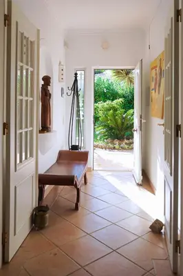 a hallway with a bench and an open door at Villa Pinheiro Manso in Albufeira