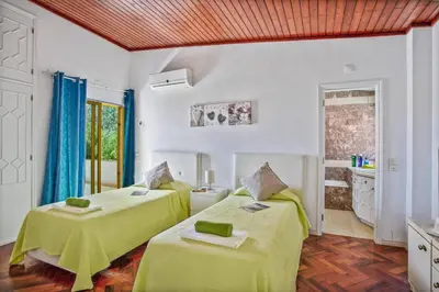 a bedroom with two beds with green sheets at Villa Miralago by Villa Plus in Vilamoura