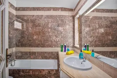 a bathroom with a tub and a sink and a mirror at Villa Miralago by Villa Plus in Vilamoura