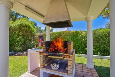 an outdoor kitchen with a stove and a grill at Villa Miralago by Villa Plus in Vilamoura