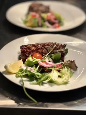 a plate of food with a salad and steak at Albufeira Central 7 by Homing in Albufeira