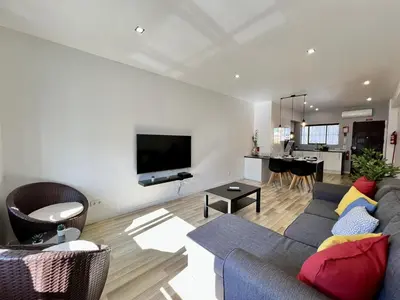 a living room with a blue couch and a kitchen at Albufeira Central 7 by Homing in Albufeira