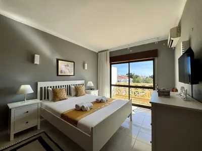 a bedroom with a bed with a green blanket at Albufeira Central 8 by Homing in Albufeira