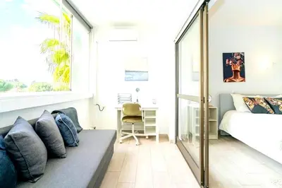 a white bedroom with a bed and windows at Spacious 1 bed in Vilamoura, Fast Wifi & Pool in Quarteira