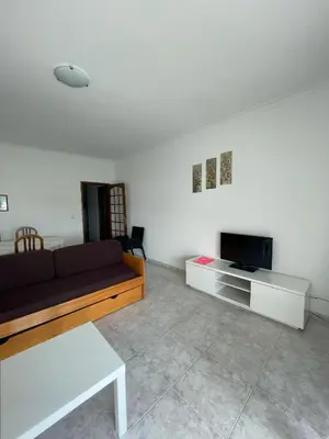 a living room with a couch and a tv at Apartamento T1 todo equipado in Albufeira