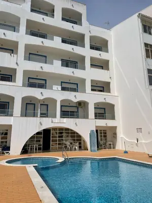 a hotel with a swimming pool in front of a building at Apartamento T1 todo equipado in Albufeira