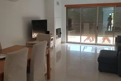 a living room with a table and chairs and a television at Casa Praia Patroves in Patroves
