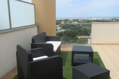 a room with two chairs and a table and a window at Casa Praia Patroves in Patroves