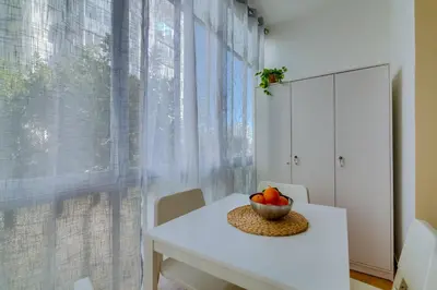 a white table and chair with a bowl of fruit on it at AL - Beachside Hideaway Quarteira in Quarteira