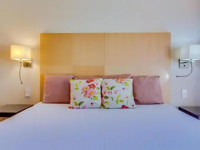 a bed with pink and white pillows on it at AL - Vila Sol Golfside Ground Floor in Vilamoura