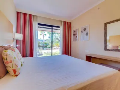 a bedroom with a large bed and a window at AL - Vila Sol Golfside Ground Floor in Vilamoura