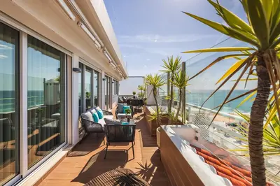 a balcony with a hot tub and a palm tree at Phenthouse Monaco - Jacuzzi - City Center - Sea View in Albufeira