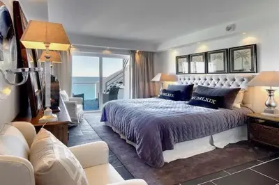 a bedroom with a large bed and a living room at Casa Chanel - Ocean front with rooftop SPA Jacuzzi in Albufeira