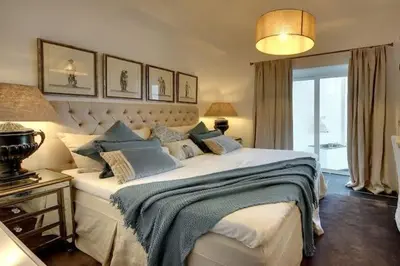 a bedroom with a large white bed with blue pillows at Casa Chanel - Ocean front with rooftop SPA Jacuzzi in Albufeira