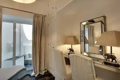 a bedroom with a bed and a desk with a mirror at Casa Chanel - Ocean front with rooftop SPA Jacuzzi in Albufeira