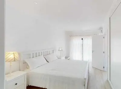 a white bedroom with a white bed and a window at Villa Malmequer by FHR private in Quarteira
