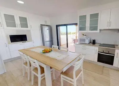 a kitchen with a table with a bowl of fruit on it at Villa Malmequer by FHR private in Quarteira
