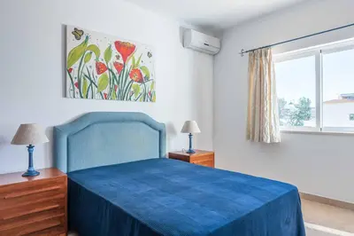 a bedroom with a blue bed and a painting on the wall at Villa Sofy in Galé