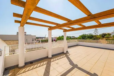 a large patio with a roof with a wooden pergola at Villa Marco in Galé