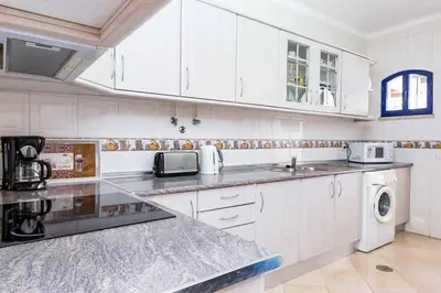 a white kitchen with a sink and a microwave at Villa Marco in Galé
