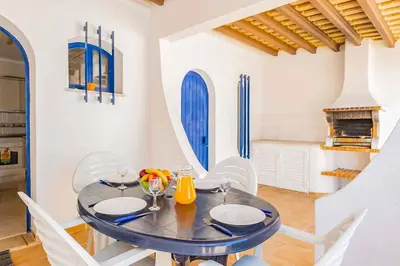 a dining room with a glass table and white chairs at Villa Marco in Galé
