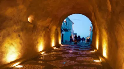 an alleyway with people walking down a street at 3 min walking to the beach & Old Town by Algarve Dream Holidays in Albufeira