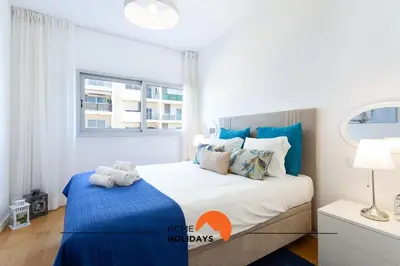 a bedroom with a large bed with blue accents at #200 Panoramic Flat by Home Holidays in Albufeira