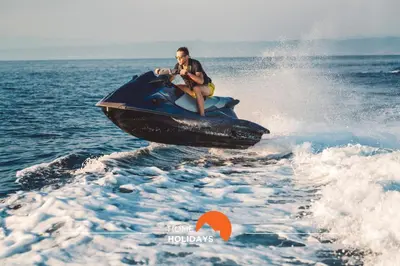a man riding a jet ski in the water at #200 Panoramic Flat by Home Holidays in Albufeira