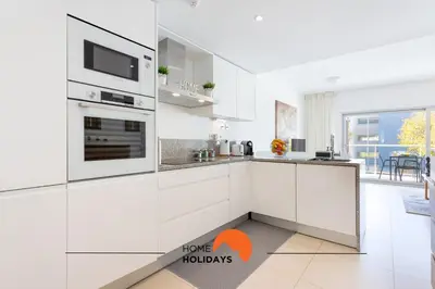 a kitchen with white cabinets and a stove top oven at #200 Panoramic Flat by Home Holidays in Albufeira