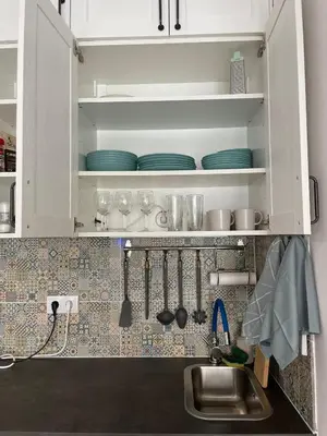 a kitchen with white cabinets and a sink and plates at Domek v srdci Fara in Faro