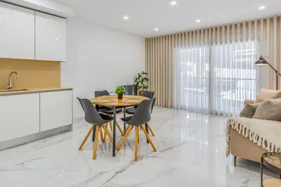 a kitchen and dining room with a table and chairs at Sublime and Bright 2 BDR Apartment by LovelyStay in Quarteira