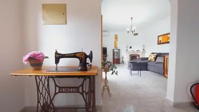 a living room with a sewing machine on a table at Vivenda Atanázio By Férias com Sol in Loulé