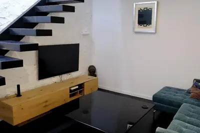 a living room with a tv and a staircase at Quinta Amarela XL by Portucasa in Loulé