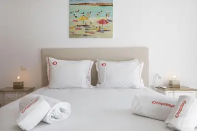 a bedroom with a bed with towels on it at Modern 1BR Apartment in Central Albufeira with Balcony & Parking, by Hopstays in Albufeira