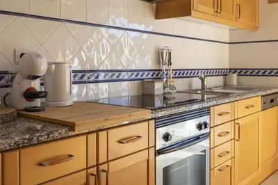 a kitchen with a sink and a counter top at Modern 1BR Apartment in Central Albufeira with Balcony & Parking, by Hopstays in Albufeira
