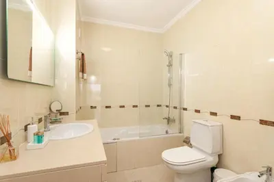 a bathroom with a toilet and a sink and a tub at Modern 1BR Apartment in Central Albufeira with Balcony & Parking, by Hopstays in Albufeira